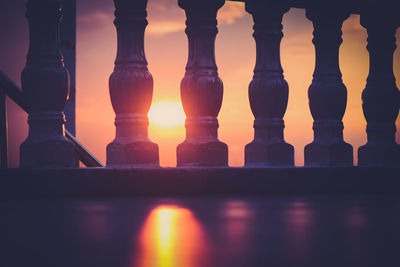 Close-up of railing against sky during sunset 