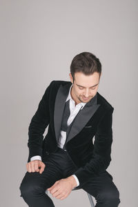 Full length of young man sitting against white background