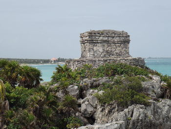 Rock formations by sea against sky