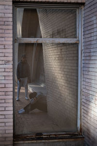 Rear view of woman standing against wall