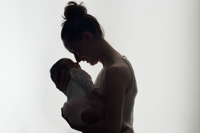 Side view of woman standing against white background