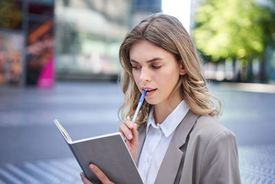 Young woman using mobile phone while sitting on table