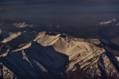 Scenic view of snowcapped mountains against sky at night