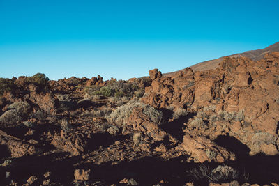 Rock formations against clear blue sky