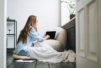 Side view of young woman using mobile phone