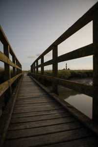 Footbridge over water against clear sky