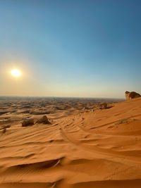 Sand dunes in desert against sky