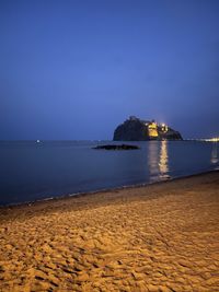 Scenic view of sea against clear sky at night