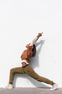 Woman climbing on wall against white background