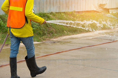 Low section of man pouring water at construction site