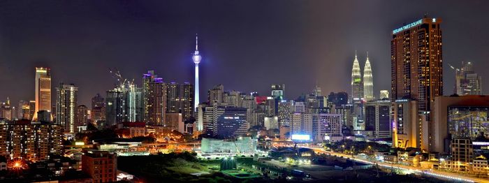 Petronas towers amidst illuminated cityscape at night