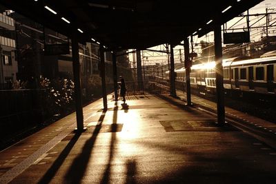 Shadow of man on illuminated railroad station platform