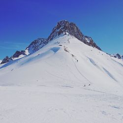 Scenic view of snowcapped mountains against clear blue sky