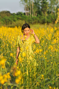 Portrait of smiling young woman standing on field