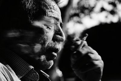 Close-up of man smoking cigarette outdoors