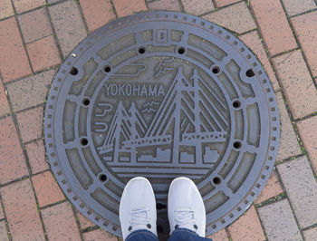 Low section of man standing on manhole