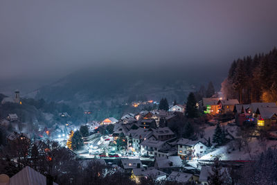 Illuminated city against sky at night