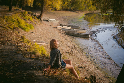 Woman sitting by lake