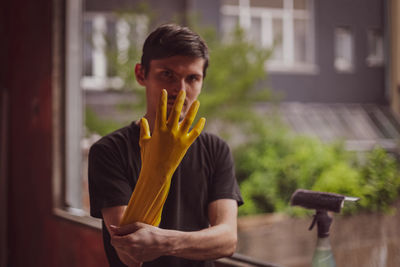 A young caucasian man is repairing a window opening, removing the silicone insulation.