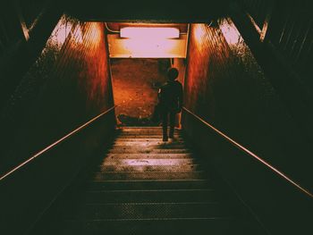 Full length rear view of person moving down on staircase