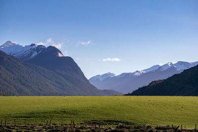 Scenic view of field and mountains against sky