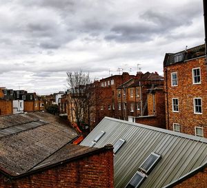 High angle view of buildings in town against cloudy sky