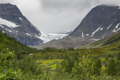 Scenic view of mountains against cloudy sky