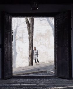 Rear view of woman standing by window