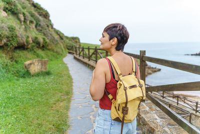 Side view of young woman standing against mountain