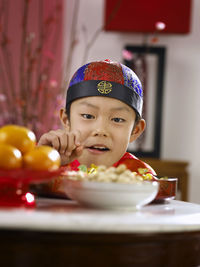 Close-up of boy picking food in container at table
