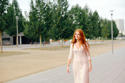 Portrait of woman standing against trees