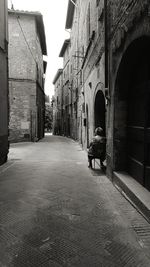 Rear view of man on street amidst buildings