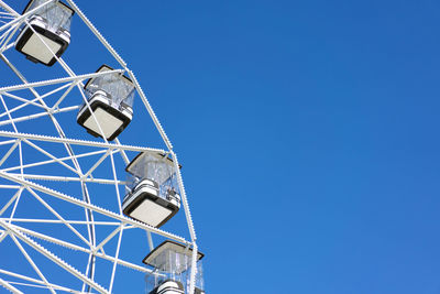 Low angle view of ferris wheel against blue sky