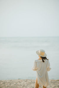 Rear view of woman standing on beach