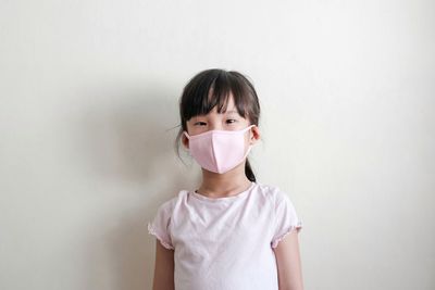 Portrait of boy standing against white background