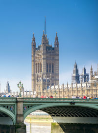 Arch bridge and buildings against sky in city