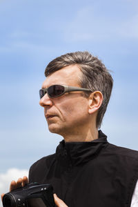 Portrait of man wearing sunglasses against sky