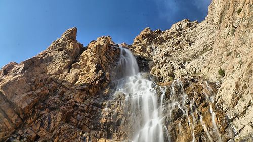 Low angle view of waterfall against sky