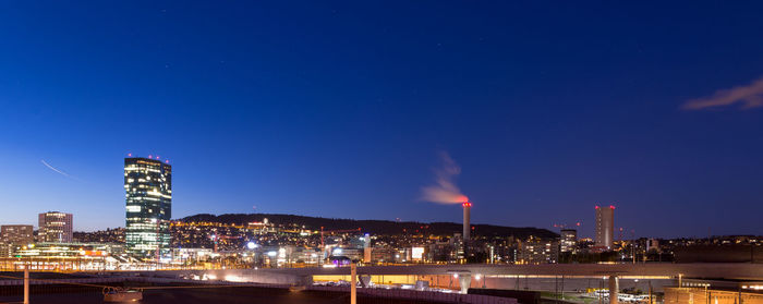 Illuminated buildings in city against sky at night