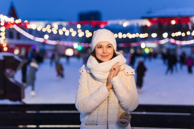 Portrait of young woman standing in city at night