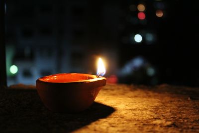 Close-up of diya on retaining wall at night