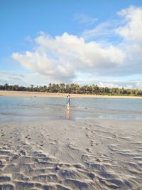 Woman on beach against sky