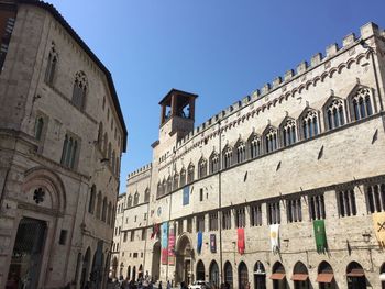 Low angle view of buildings against clear blue sky