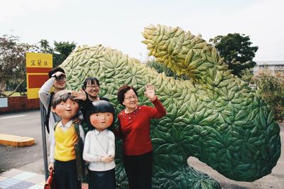 Happy family standing by statues at public park