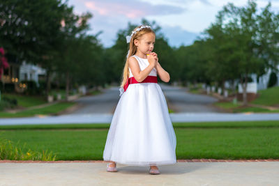 Cute girl standing at park during sunset