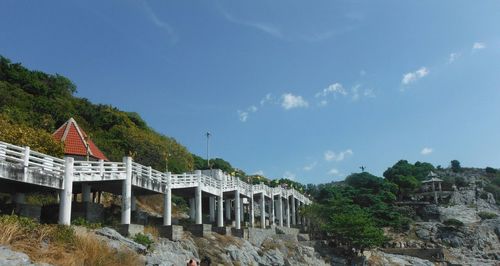 Arch bridge over river amidst buildings against sky