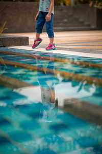 Low section of woman standing in swimming pool