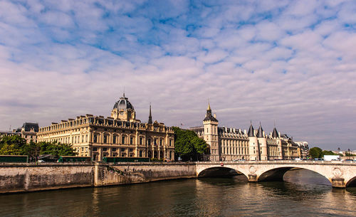 Arch bridge over river against buildings in city