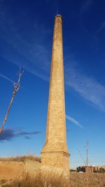 Low angle view of windmill against blue sky