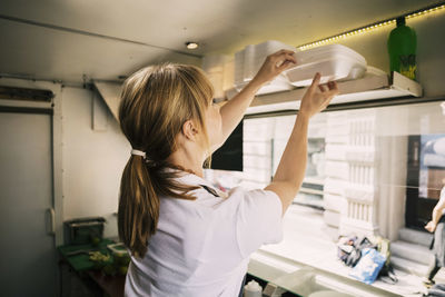 Blond hair woman working in street food truck